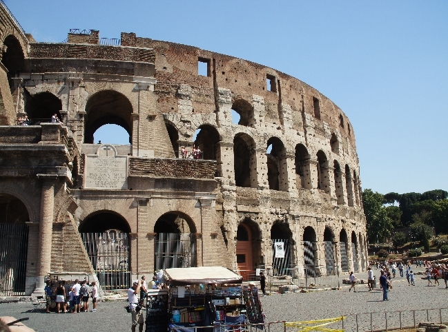 Der Name Kolosseum ergibt sich aus einer ca. 32 m hohen Kolossalstatue Neros aus vergoldeter Bronze, die an der heute durch ein Beet mit Bäumen gekennzeichneten Stelle, vor dem Ausgang der U-Bahn stand.